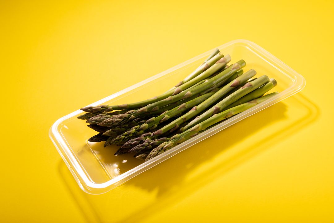 Close-up of asparagus in container on yellow background, copy space - Free Images, Stock Photos and Pictures on Pikwizard.com