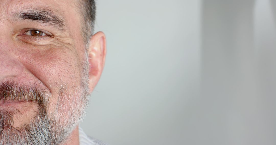 Smiling middle-aged man facing camera with graying beard closeup headshot and copy space