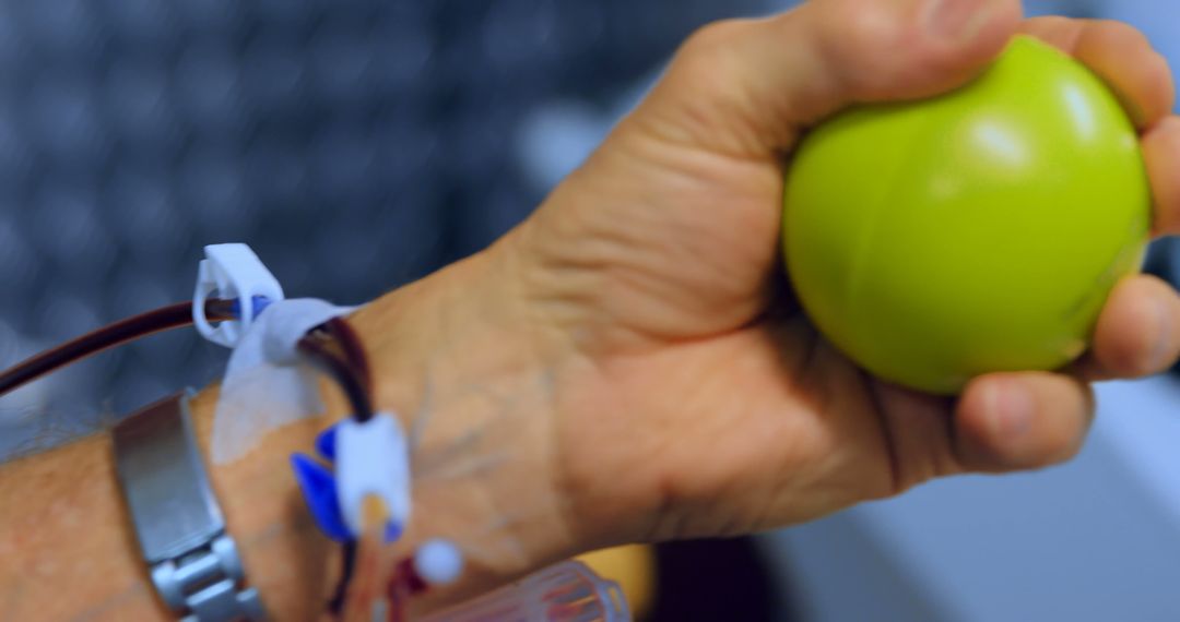 Close-up of Donor's Hand Squeezing Stress Ball During Blood Donation - Free Images, Stock Photos and Pictures on Pikwizard.com