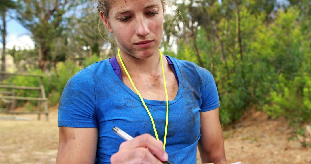 Female sports coach writing notes outdoors during training - Free Images, Stock Photos and Pictures on Pikwizard.com