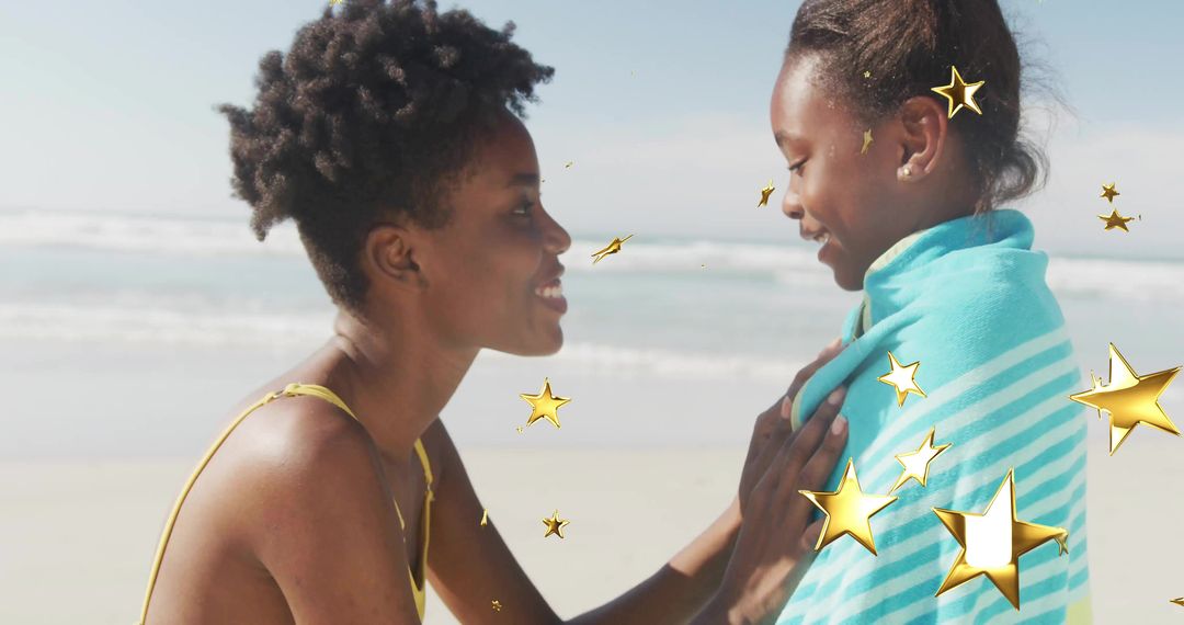Mother Wrapping Daughter in Towel with Star Overlay on Sunny Beach