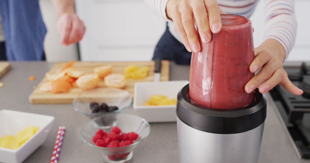 Person blending homemade fruit smoothie in modern kitchen - Free Images, Stock Photos and Pictures on Pikwizard.com