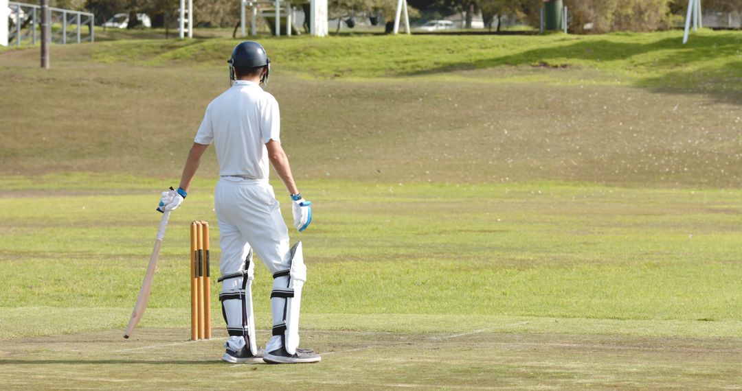 Cricketer Standing on Pitch with Bat Facing Stumps