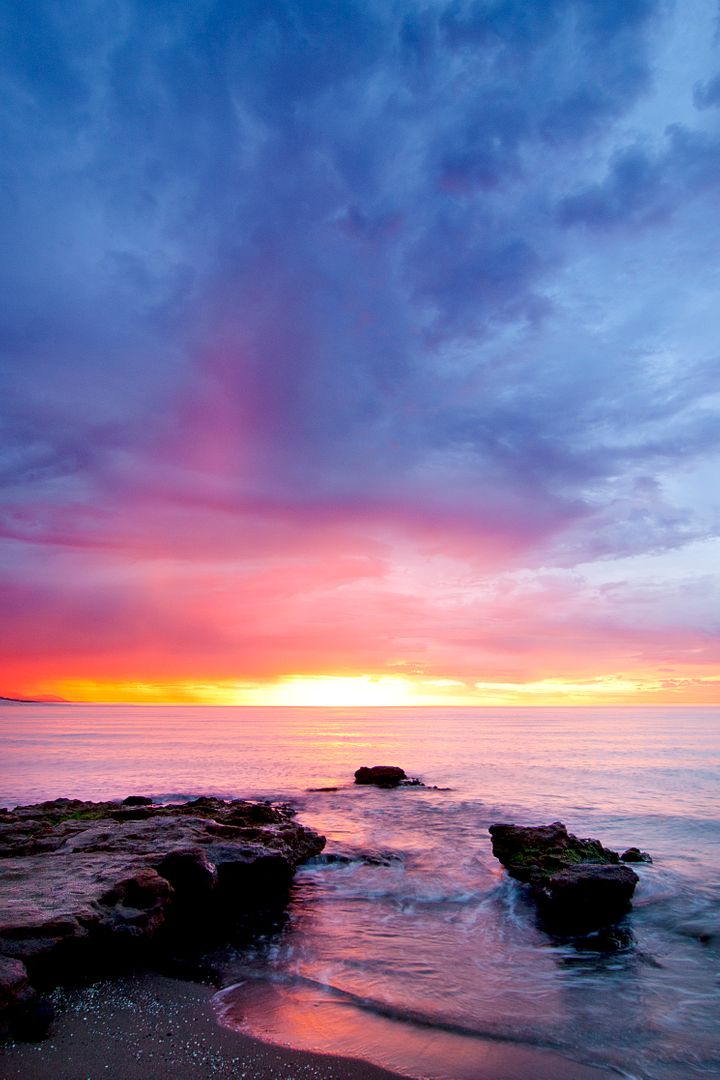 Stunning Sunset Over Ocean with Reflecting Sky and Rocky Shoreline - Free Images, Stock Photos and Pictures on Pikwizard.com