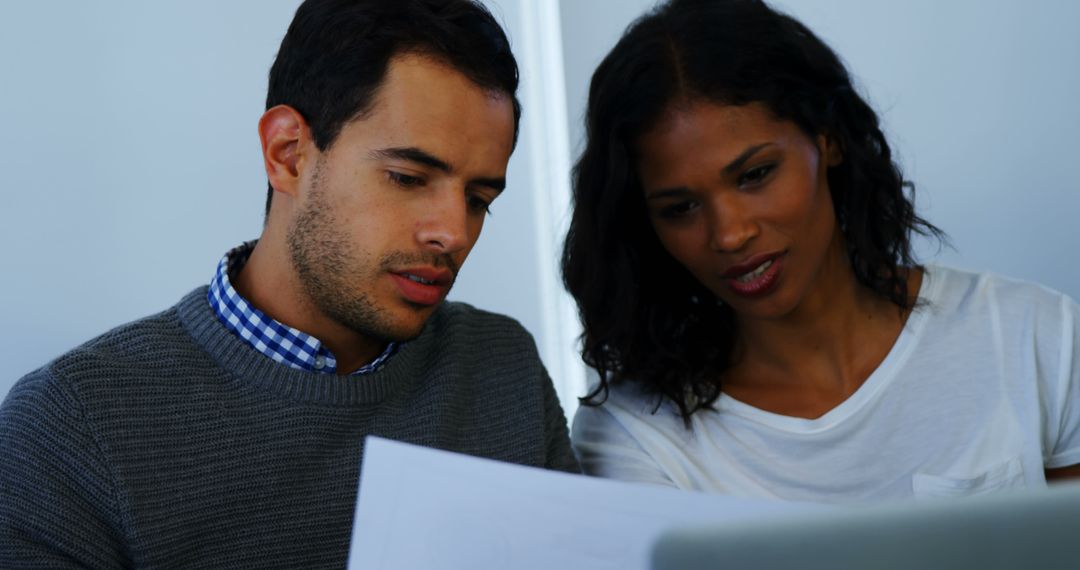 Diverse Team Collaborating Over Document at Office