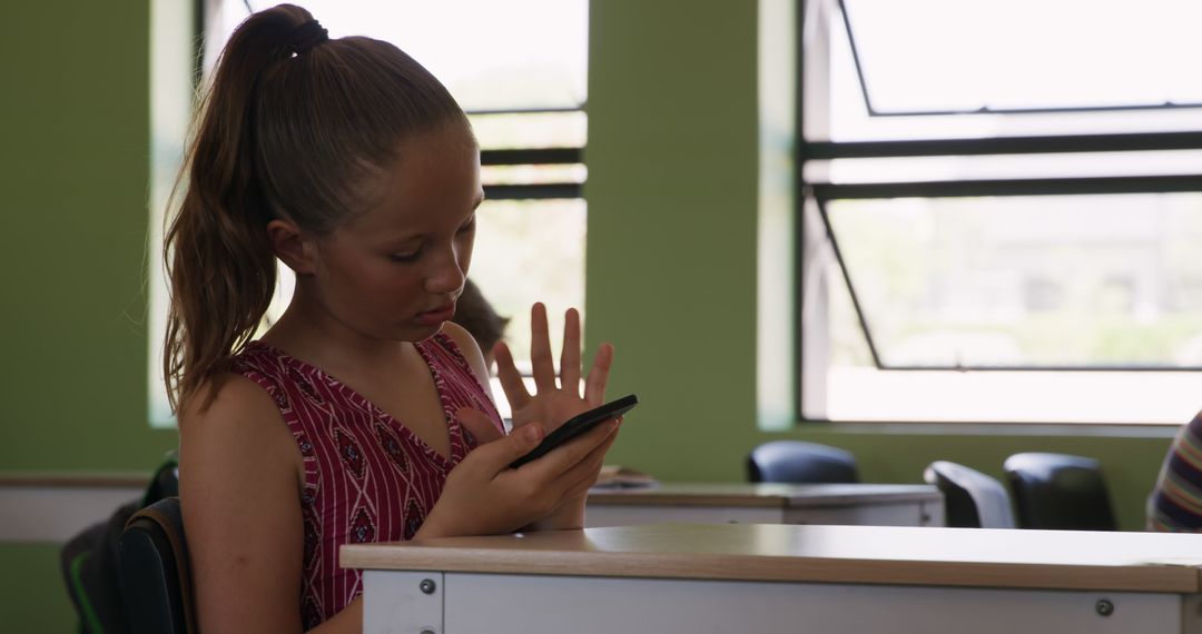 Teen Girl Using Smartphone in Classroom with Green Walls - Free Images, Stock Photos and Pictures on Pikwizard.com