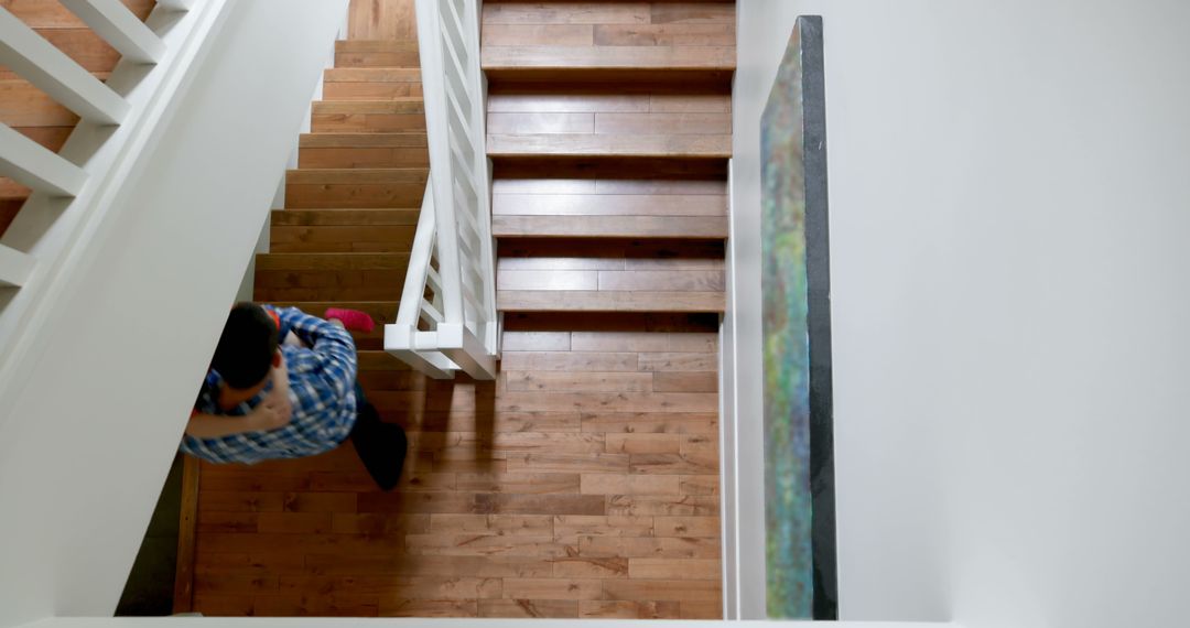 Father Carrying Daughter on Wooden Staircase in Cozy Home - Free Images, Stock Photos and Pictures on Pikwizard.com