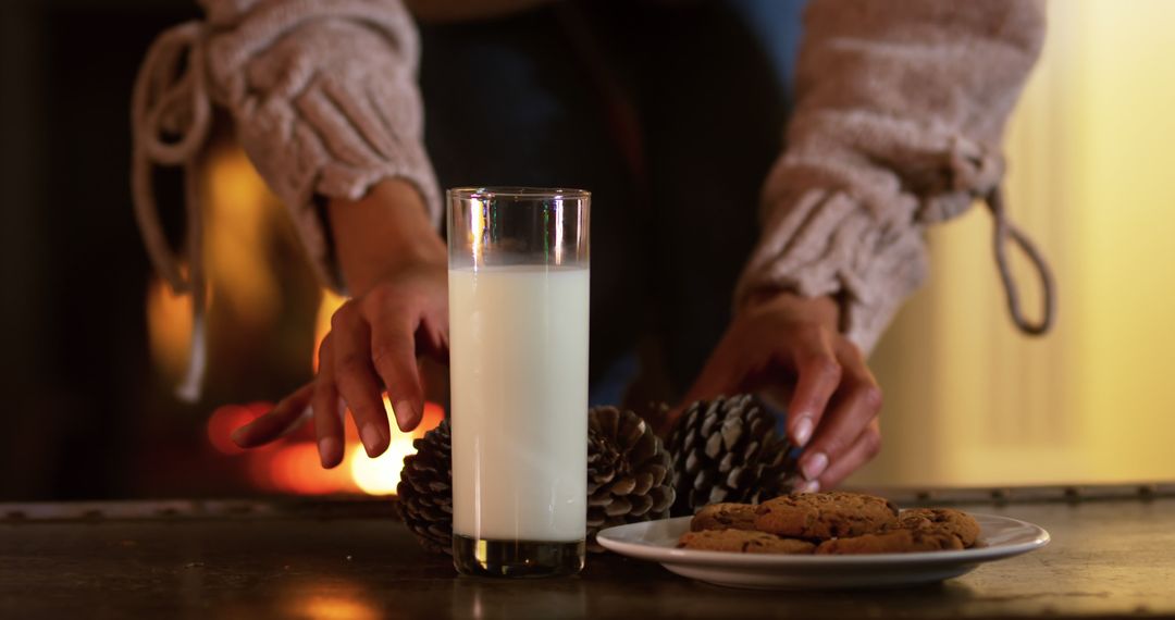 Hands Setting Milk and Cookies by Cozy Fireplace at Home - Free Images, Stock Photos and Pictures on Pikwizard.com