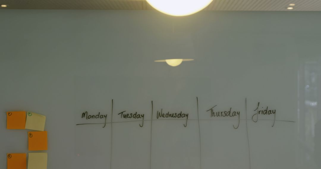 Office Weekly Planning on Glass Board with Sticky Notes