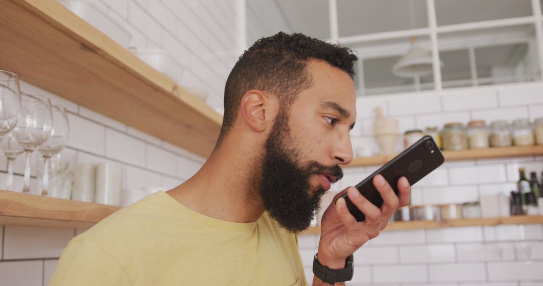 Man Engaging with Smartphone in Modern Kitchen Environment