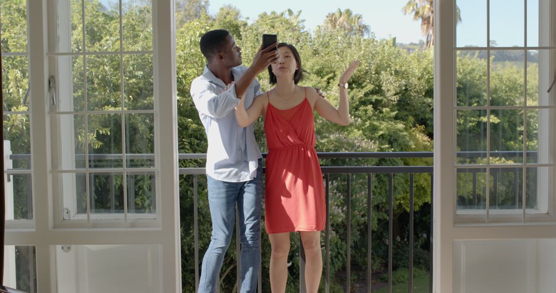 Joyful Couple Taking Selfie on a Balcony with Scenic View