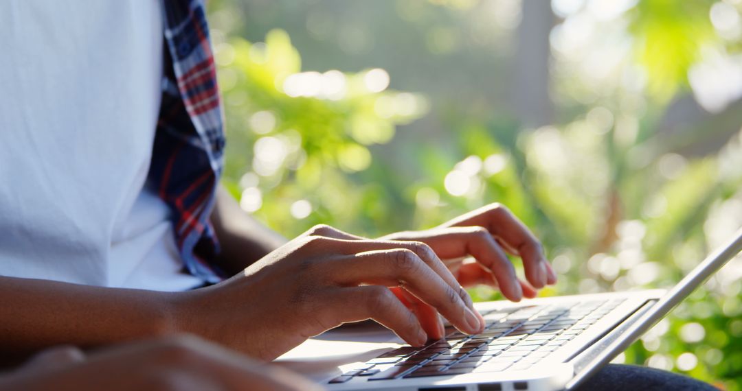 Twin Sisters Using Laptop Outdoors in Sunny Park Setting