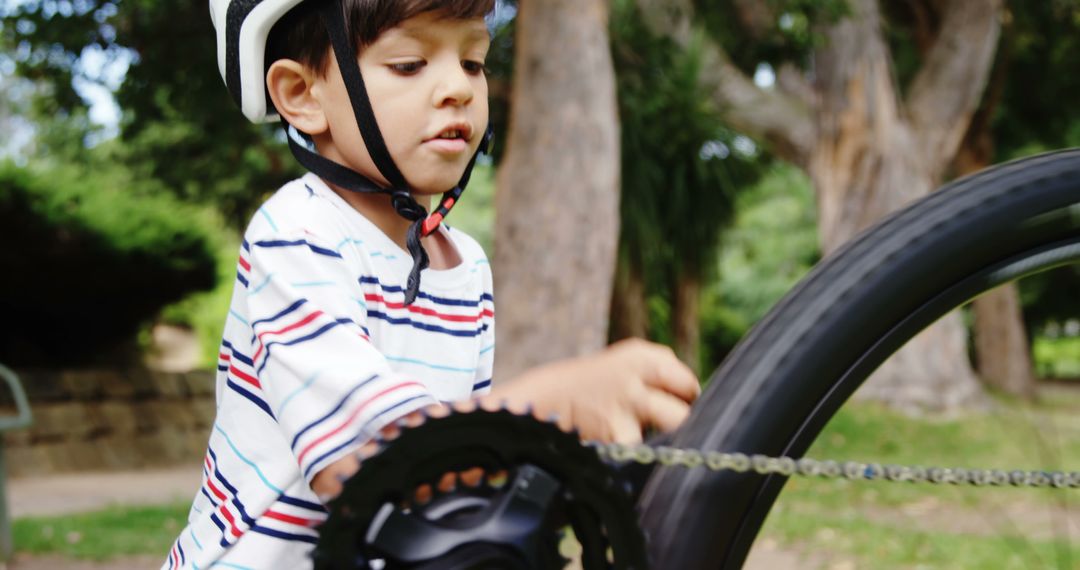 Young Boy in Helmet Repairing Bicycle in Park - Free Images, Stock Photos and Pictures on Pikwizard.com