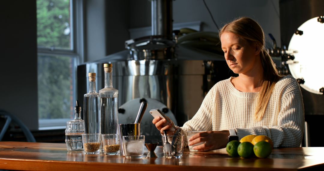 Woman Texting at Bar with Drinks and Citrus in Relaxed Setting