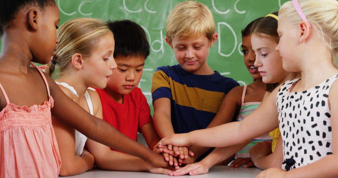 Diverse Group of Children Stacking Hands in Classroom - Free Images, Stock Photos and Pictures on Pikwizard.com