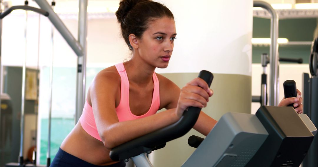 Young Woman Working Out on Elliptical Machine at Gym - Free Images, Stock Photos and Pictures on Pikwizard.com