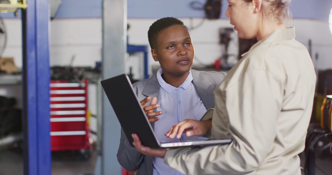 Image of two diverse car mechanic and business owner with laptop searching for car parts - Free Images, Stock Photos and Pictures on Pikwizard.com