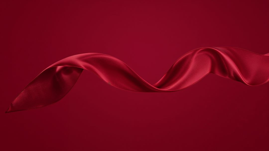 Twisting Red Satin Ribbon in Motion on Red Background