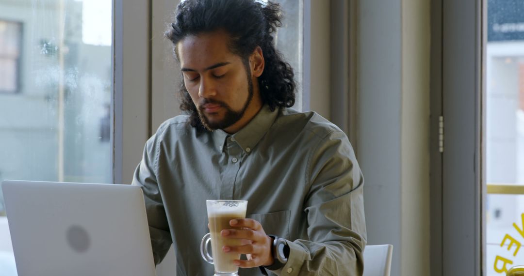 African American Man Working on Laptop at Coffee Shop with Latte - Free Images, Stock Photos and Pictures on Pikwizard.com