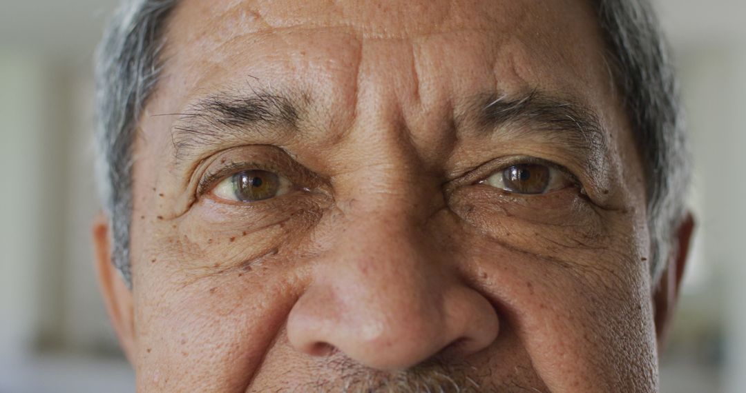 Elderly man's eyes showing deep wrinkles, serious expression, close-up view - Free Images, Stock Photos and Pictures on Pikwizard.com