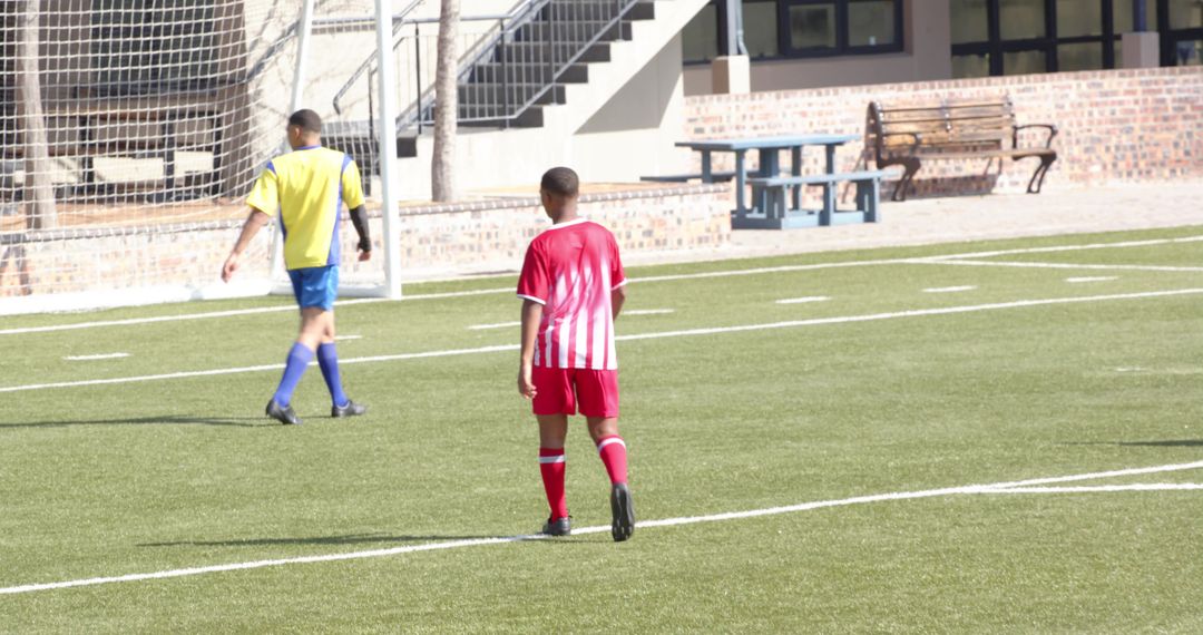 Young Soccer Player Walking on Field During Practice