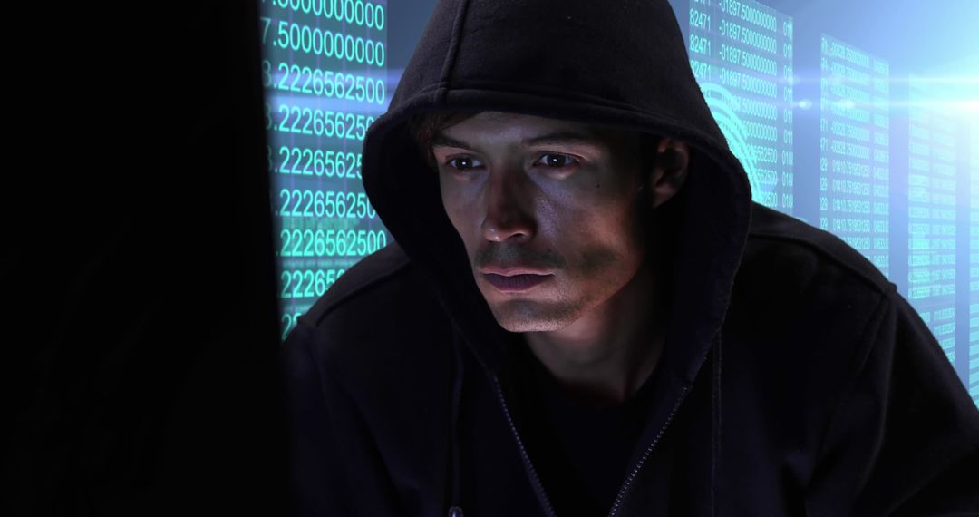 Focused Hacker Wearing Hoodie in Computer Lab
