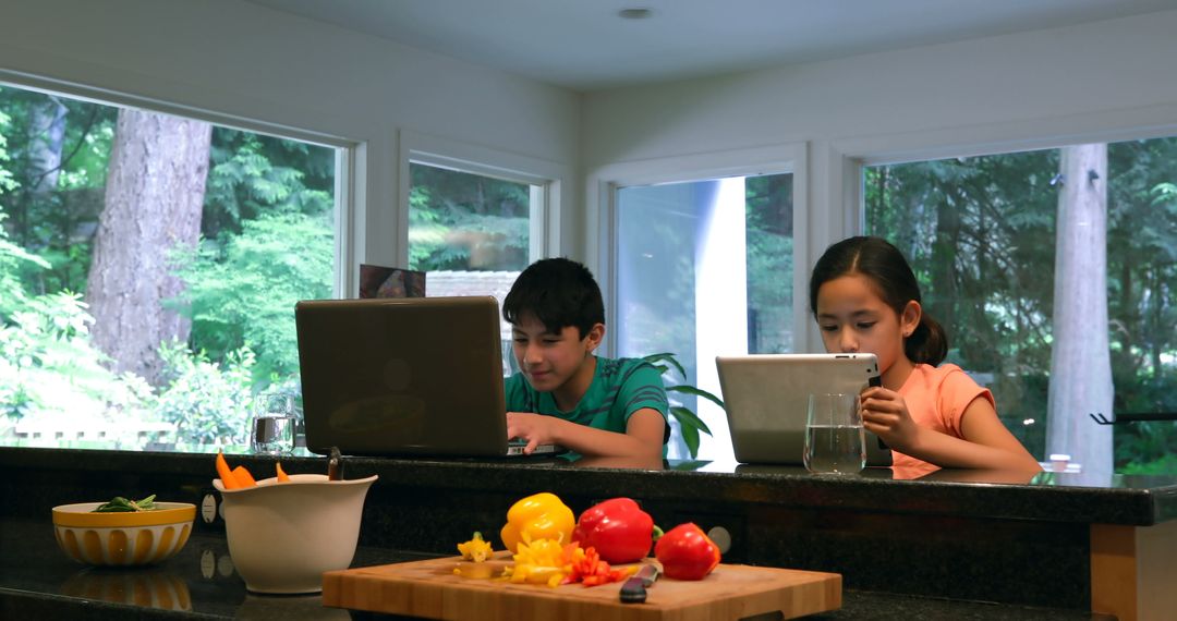 Children Using Devices in Kitchen with Healthy Snacks on Counter - Free Images, Stock Photos and Pictures on Pikwizard.com