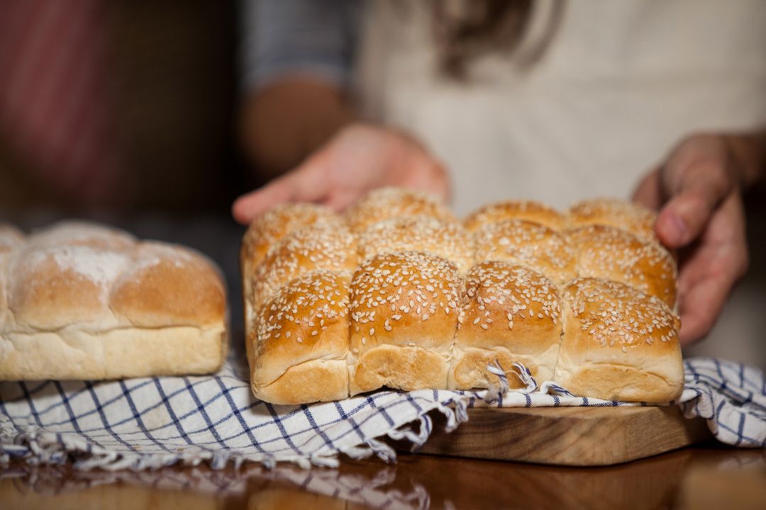 Mid-section of woman holding bread at counter - Free Images, Stock Photos and Pictures on Pikwizard.com