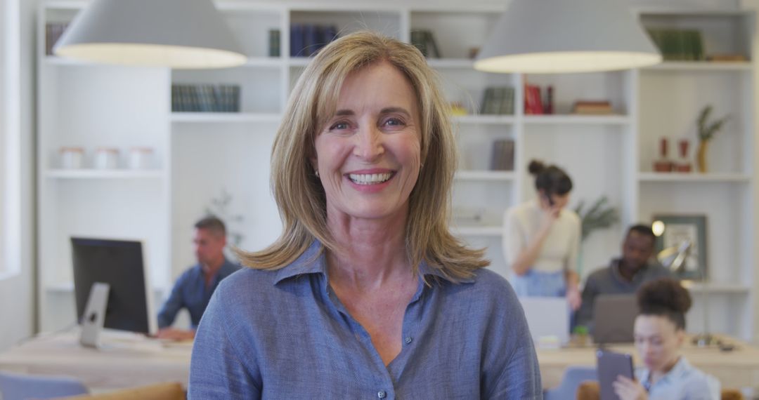 Smiling Businesswoman in Office Environment with Colleagues