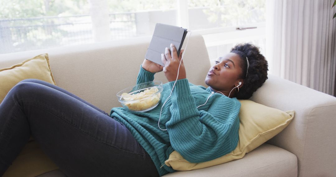 Woman Relaxing on Couch With Tablet and Snack - Free Images, Stock Photos and Pictures on Pikwizard.com