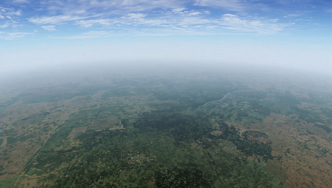 High-altitude view of sprawling agricultural plains, patchwork fields, winding river