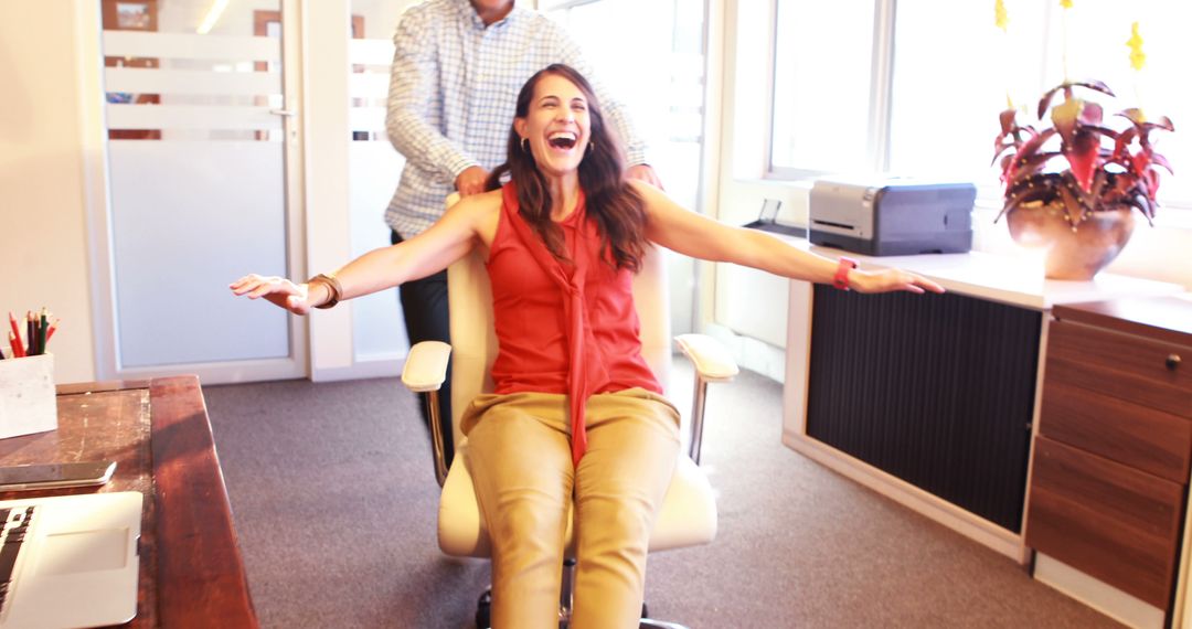 Colleagues Enjoying Chair Race in Bright Office - Free Images, Stock Photos and Pictures on Pikwizard.com