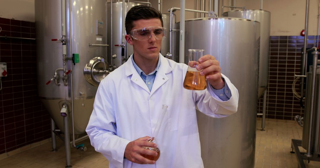 Male scientist working in brewery inspecting liquid samples - Free Images, Stock Photos and Pictures on Pikwizard.com