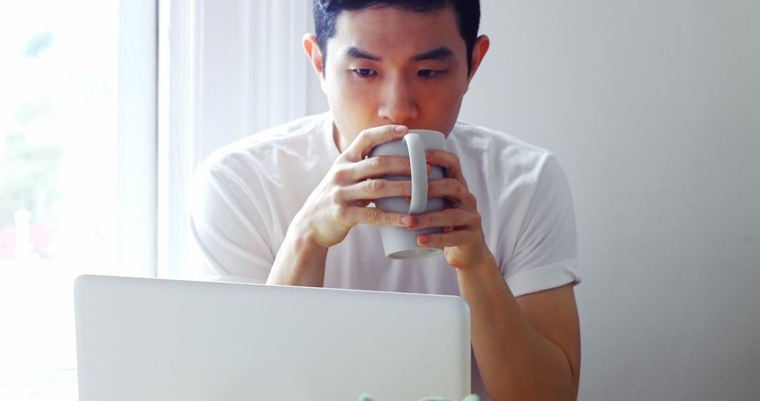 Man Drinking Coffee While Working on Laptop at Home - Free Images, Stock Photos and Pictures on Pikwizard.com