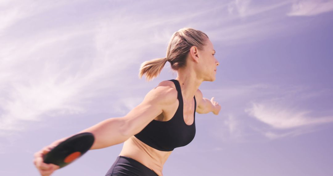 Female Athlete Throwing Discus Under Blue Sky - Free Images, Stock Photos and Pictures on Pikwizard.com