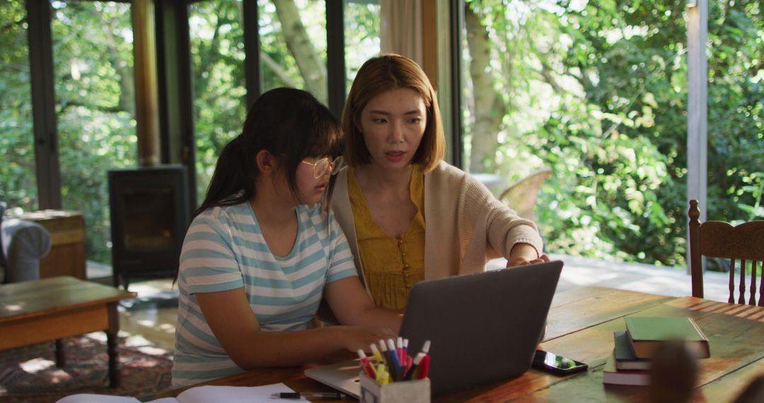 Asian mother and daughter using laptop at home - Free Images, Stock Photos and Pictures on Pikwizard.com