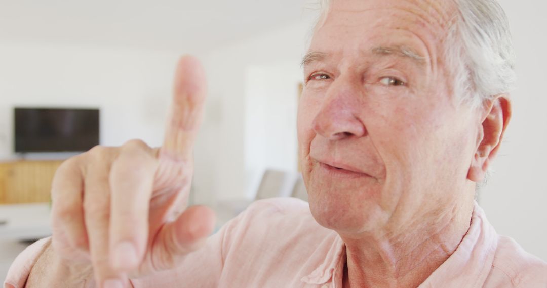 Senior Man Pointing Finger with Focused Expression Indoors - Free Images, Stock Photos and Pictures on Pikwizard.com