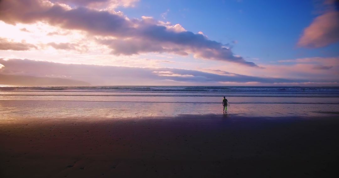 Solitary Child Walking Along the Beach at Sunset with Vibrant Skies - Free Images, Stock Photos and Pictures on Pikwizard.com