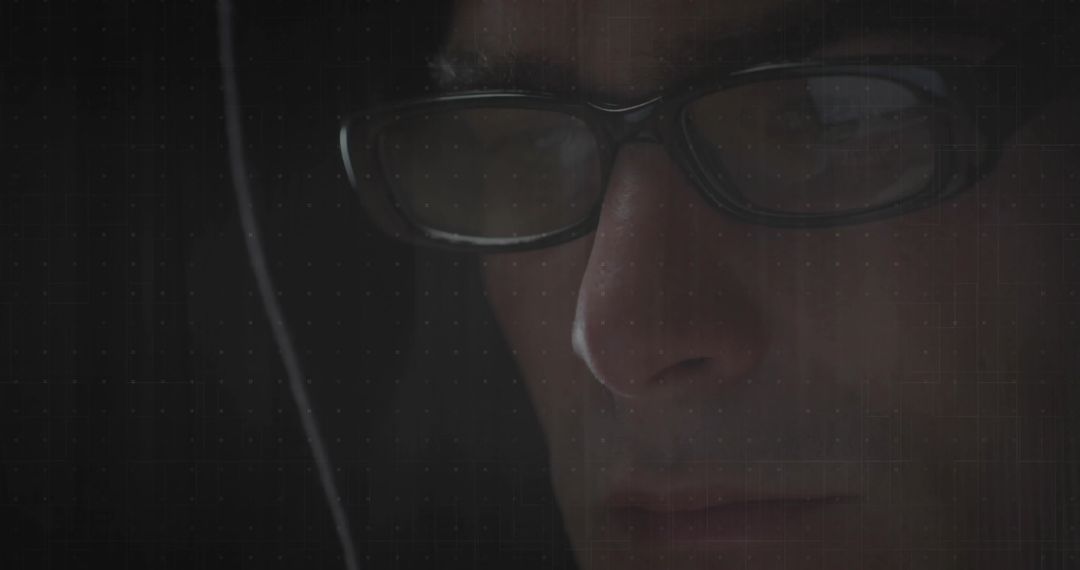 Mystery Man in Hood Analyzing in Dim Light illustrates Tech Focus