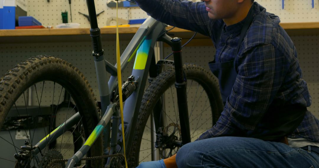 Man Repairing Bicycle in Workshop Wearing Protective Gloves - Free Images, Stock Photos and Pictures on Pikwizard.com