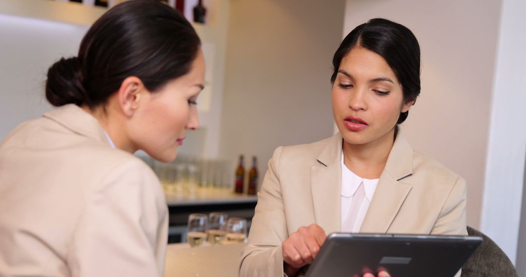 Businesswomen discussing information on tablet in office environment - Free Images, Stock Photos and Pictures on Pikwizard.com