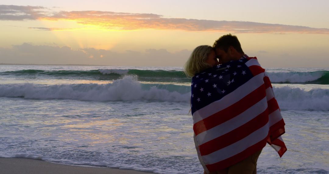 Romantic Couple Embracing with American Flag on Beach at Sunset