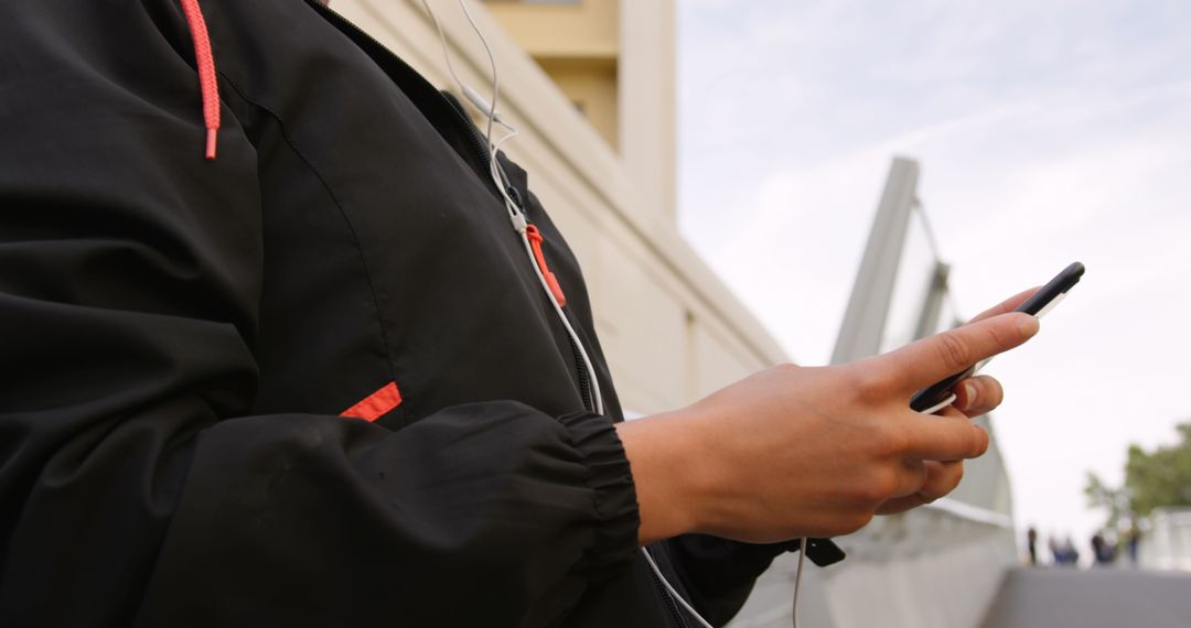 Young Woman Engaged with Smartphone in Urban Skyline