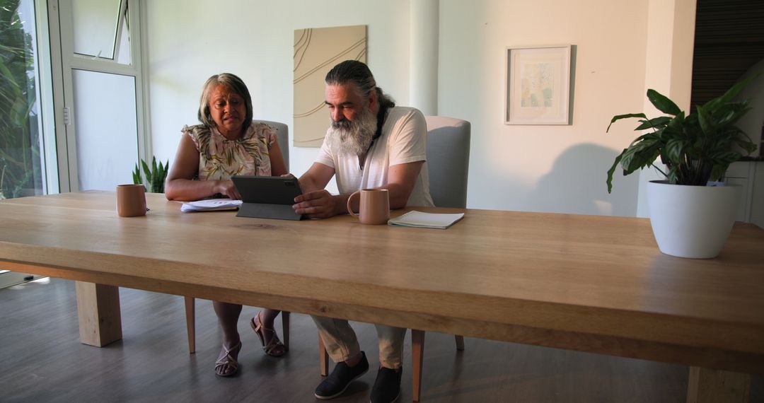 Senior Couple Analyzing Finances at Home Using Tablet