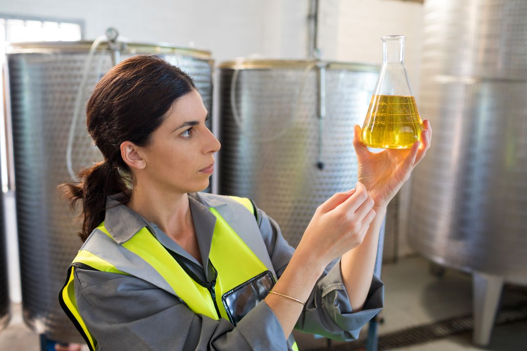 Female technician examining olive oil - Free Images, Stock Photos and Pictures on Pikwizard.com