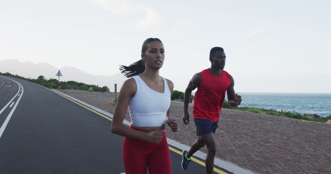 Diverse Couple Running on Scenic Coastal Road