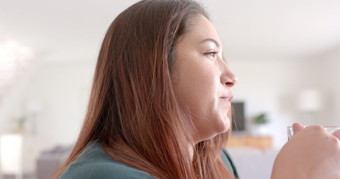Thoughtful Woman Enjoying Tea While Working from Home