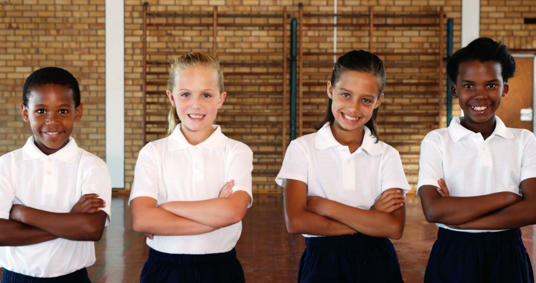 Confident Schoolchildren Standing Arm Crossed in Gym