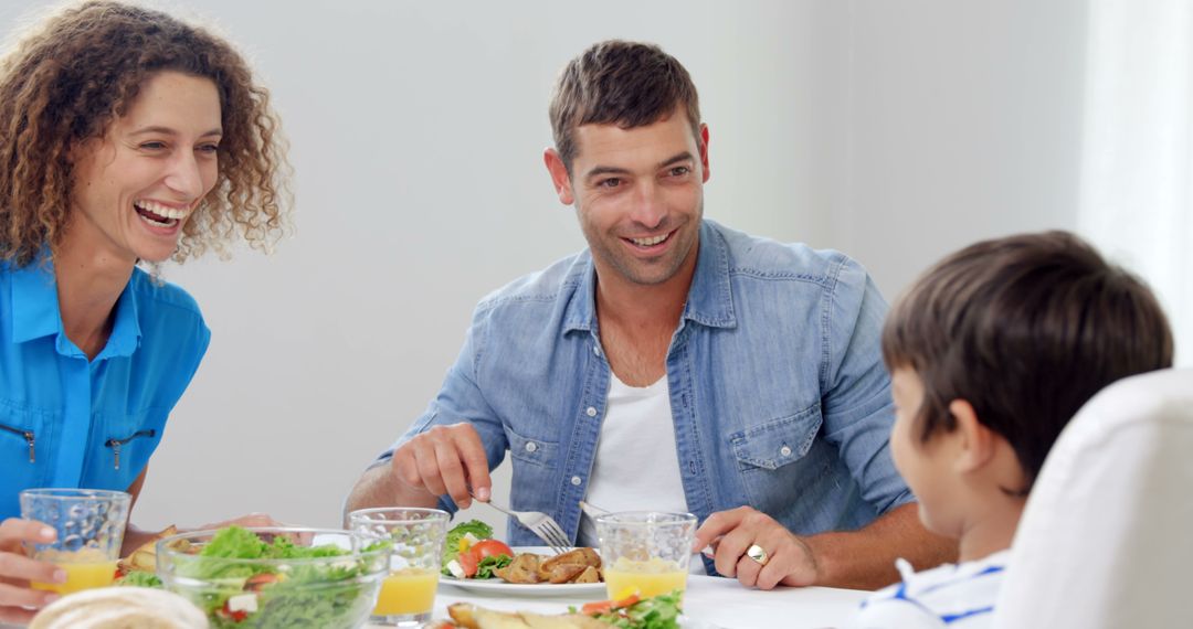 Happy Family Sharing Meal at Dining Table with Smiles - Free Images, Stock Photos and Pictures on Pikwizard.com