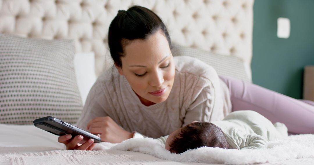 Mother Bonding with Sleeeping Baby on Bed Using Tablet